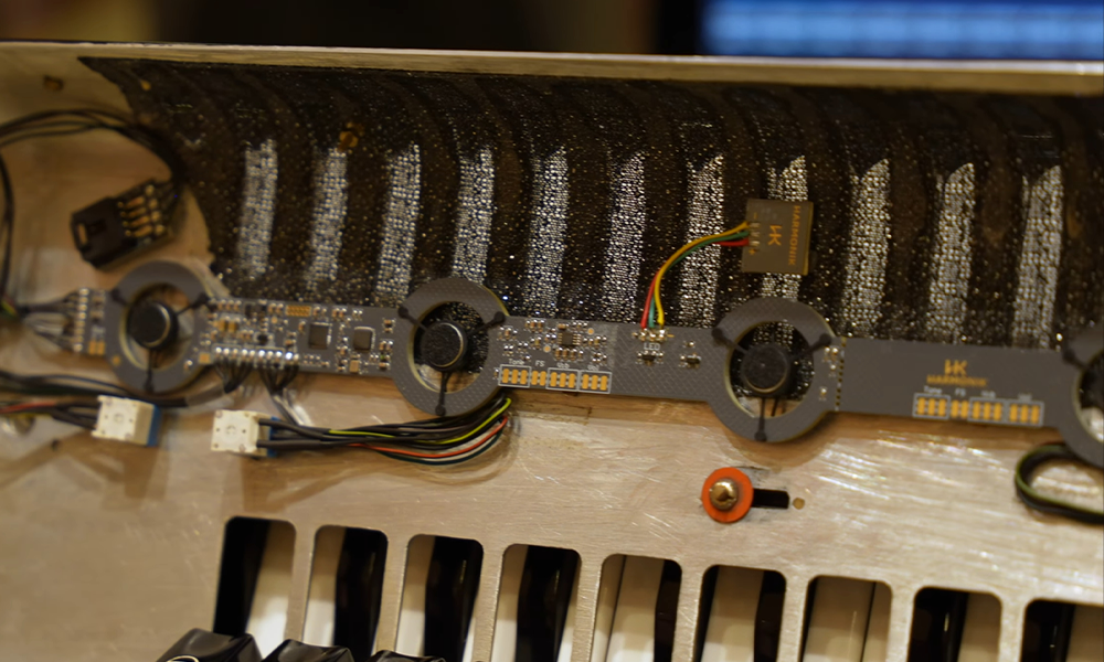 Fotografia ilustrativa em close do mecanismo de captação sonora da harmonik visto por dentro do acordeon