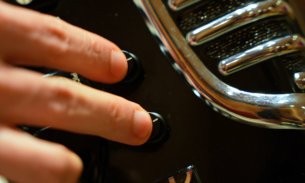 Fotografia ilustrativa com close de mãos manipulando o captador harmonik para acordeon - Oitavador e microfonia com os captadores FX/FS