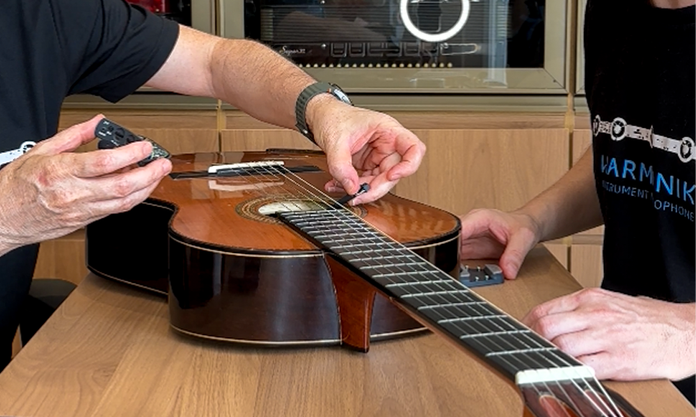 Fotografia Ilustrativa de um violão recebendo um captador harmonik microphones